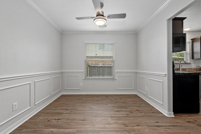 13228 Miller Ln, Willis, TX 77318 - spare room featuring ceiling fan, crown molding, wood finished floors, wainscoting, and a sink