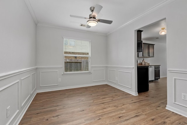 13228 Miller Ln, Willis, TX 77318 - empty room featuring a ceiling fan, wainscoting, ornamental molding, light wood-style floors, and a decorative wall