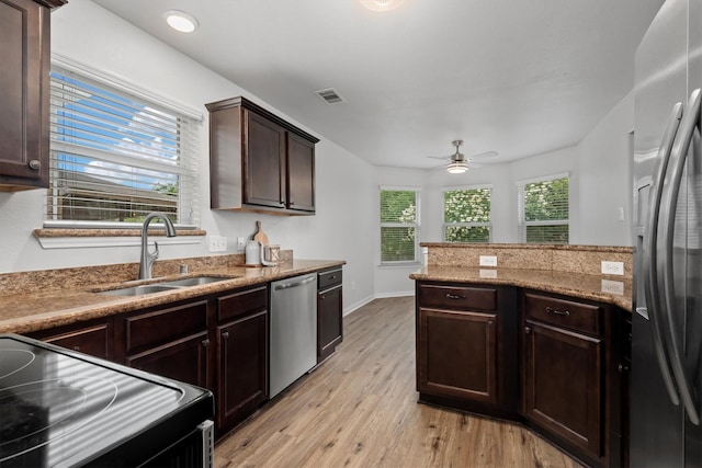 13228 Miller Ln, Willis, TX 77318 - kitchen featuring stainless steel appliances, a sink, light wood-style floors, dark brown cabinetry, and a ceiling fan