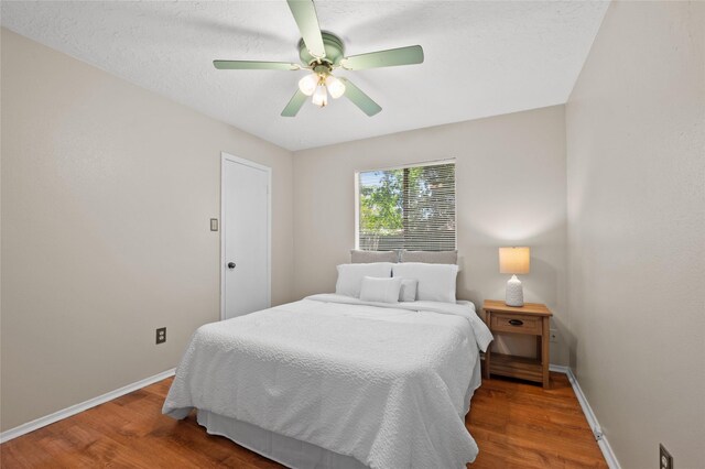 bedroom with wood finished floors, baseboards, and ceiling fan