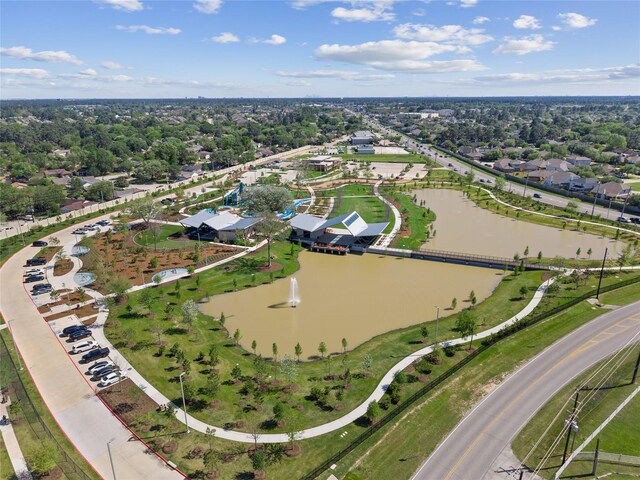 aerial view of property's location featuring a nearby body of water and a tree filled landscape