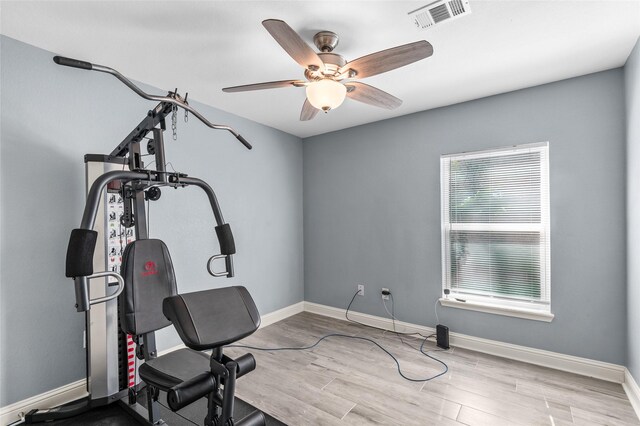 workout room featuring ceiling fan, baseboards, and wood finished floors