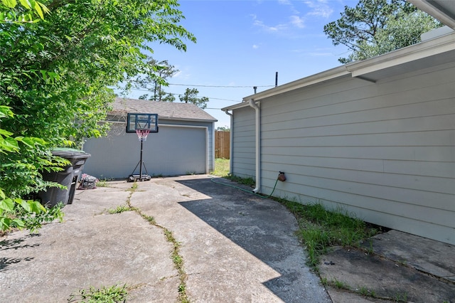 view of patio / terrace featuring a garage and an outbuilding