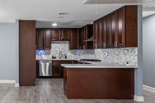 kitchen with stainless steel dishwasher, a sink, baseboards, range, and tasteful backsplash