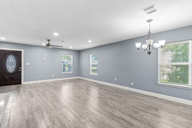 foyer with healthy amount of natural light, light wood finished floors, recessed lighting, and a chandelier