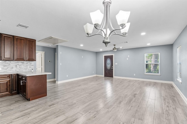 kitchen featuring light countertops, open floor plan, decorative backsplash, light wood-style flooring, and recessed lighting