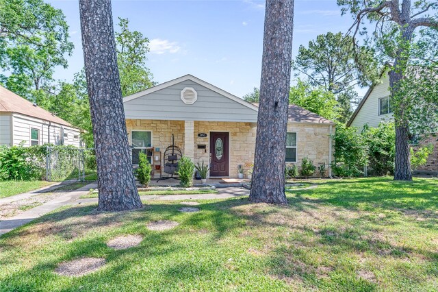 3853 Rosedale St, Houston, TX 77004 - view of front of house with stone siding, a front yard, and a porch