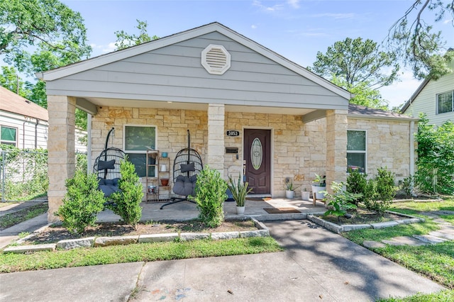 view of front facade featuring stone siding and a porch