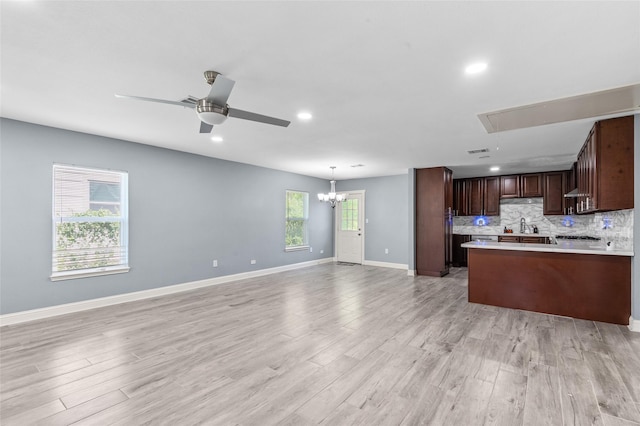 kitchen with open floor plan, light countertops, light wood finished floors, baseboards, and recessed lighting