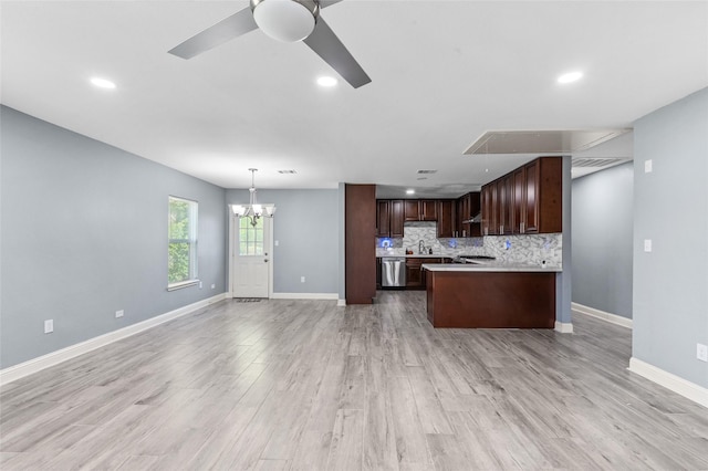 kitchen with dishwasher, light countertops, a chandelier, open floor plan, and baseboards