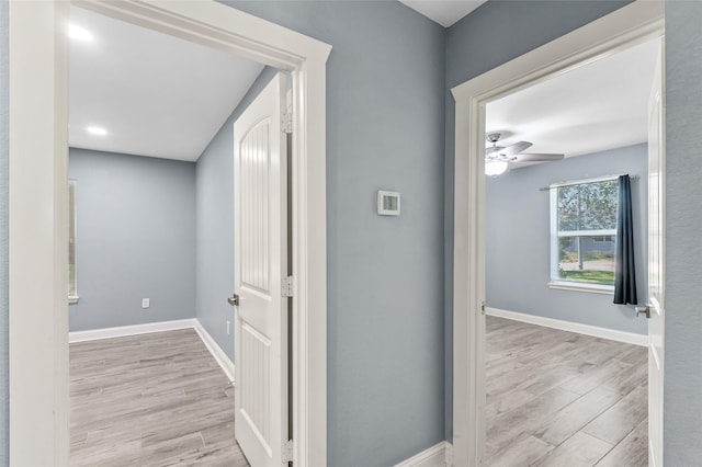 corridor with wood finished floors and baseboards