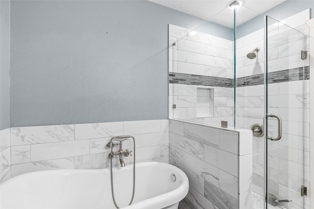 bathroom featuring a shower stall and a freestanding tub