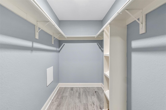 walk in closet with wood finished floors