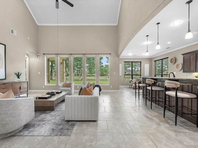 20722 Lavone Dr, Porter, TX 77365 - living room with arched walkways, ornamental molding, ceiling fan, a towering ceiling, and baseboards