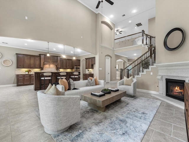 20722 Lavone Dr, Porter, TX 77365 - living room featuring a ceiling fan, arched walkways, ornamental molding, a fireplace, and a high ceiling