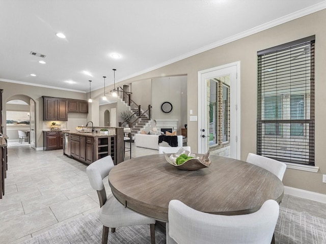 20722 Lavone Dr, Porter, TX 77365 - dining space with arched walkways, ornamental molding, stairs, baseboards, and recessed lighting