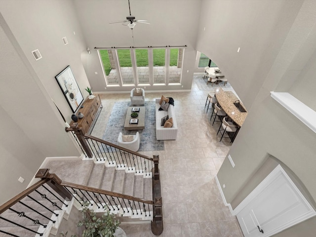 20722 Lavone Dr, Porter, TX 77365 - tiled living area with a towering ceiling, arched walkways, ceiling fan, baseboards, and stairs