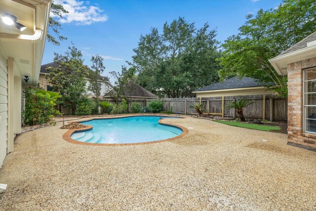 view of swimming pool with a patio and a fenced backyard