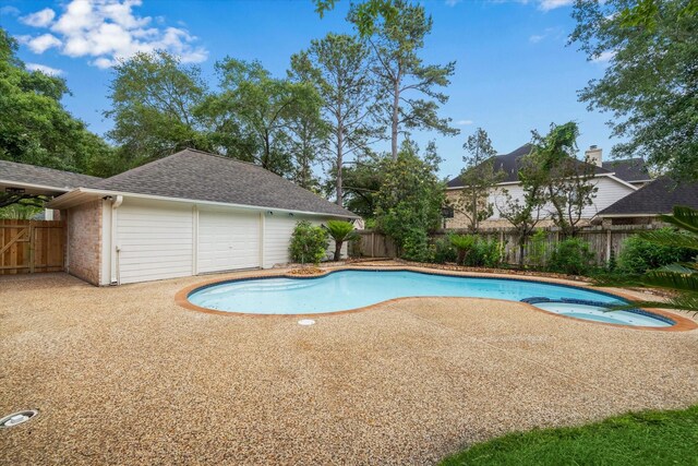 view of pool with a fenced backyard, a pool with connected hot tub, and a patio area