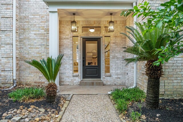 view of exterior entry with brick siding