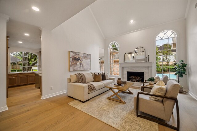living room featuring plenty of natural light, baseboards, light wood-style floors, high vaulted ceiling, and recessed lighting