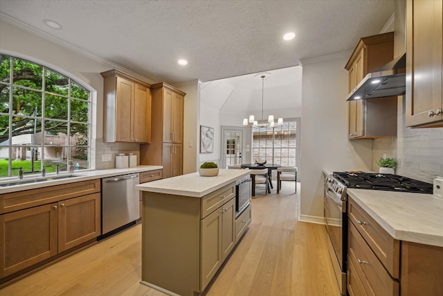 kitchen featuring appliances with stainless steel finishes, a chandelier, a sink, tasteful backsplash, and recessed lighting