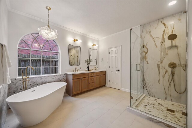 bathroom with ornamental molding, a chandelier, a marble finish shower, a freestanding tub, and double vanity