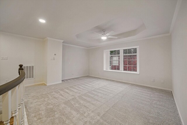 unfurnished room featuring a ceiling fan, crown molding, carpet floors, baseboards, and a tray ceiling