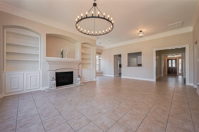 unfurnished living room featuring built in shelves, light tile patterned floors, a chandelier, crown molding, and a fireplace with raised hearth