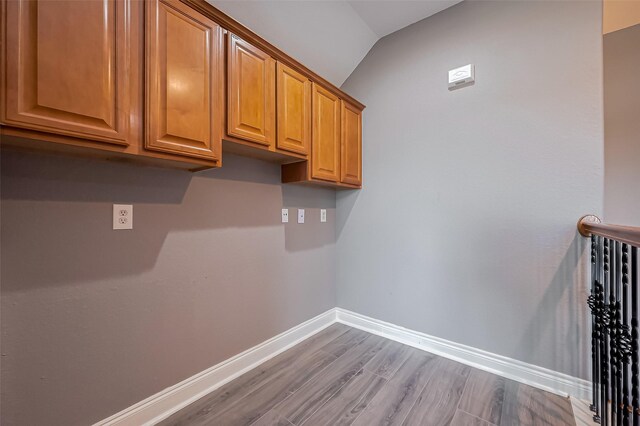laundry area featuring baseboards and wood finished floors