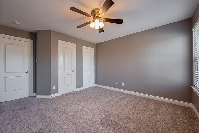 unfurnished bedroom with carpet, baseboards, and a ceiling fan