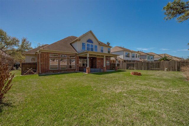 rear view of property featuring brick siding and an outdoor fire pit