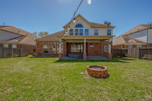 back of house with an outdoor fire pit, a patio, and brick siding