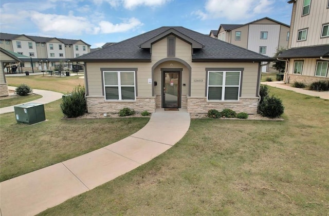 12603 Telge Rd Unit 11E-F, Cypress, TX 77429 - view of front of property featuring stone siding, a front lawn, and roof with shingles