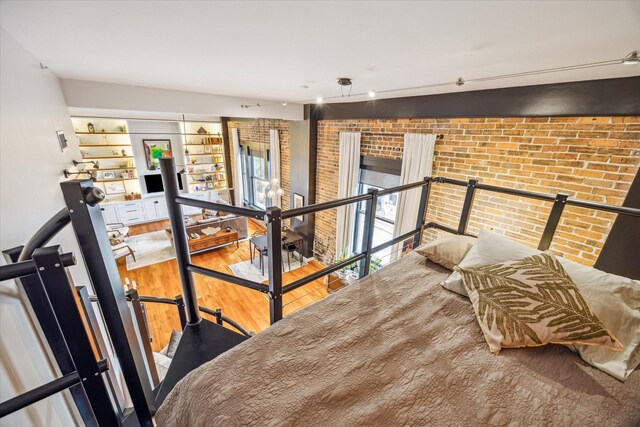 interior space with wood finished floors and brick wall