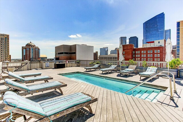 community pool featuring a skyline view and a wooden deck