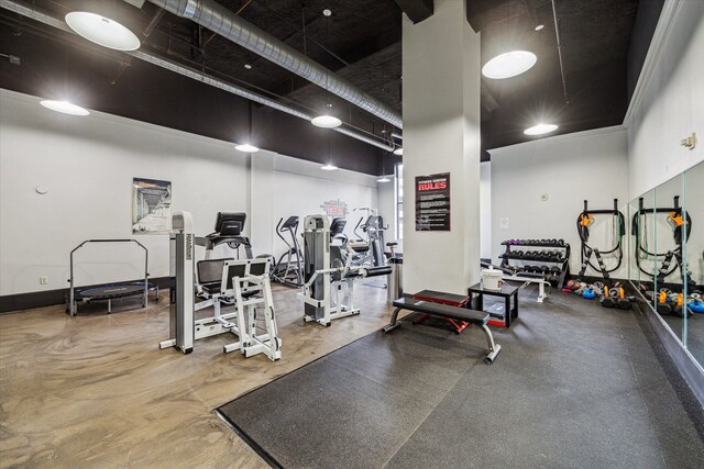 exercise room featuring a towering ceiling