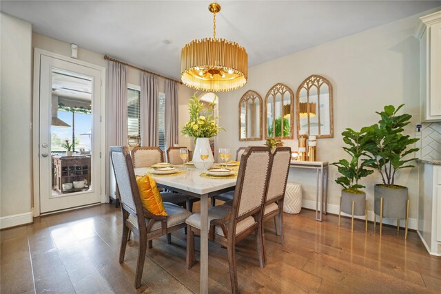 dining room featuring hardwood / wood-style flooring, baseboards, and a chandelier
