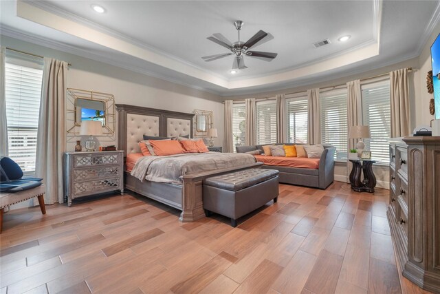 bedroom featuring a tray ceiling, crown molding, light wood-type flooring, a ceiling fan, and recessed lighting