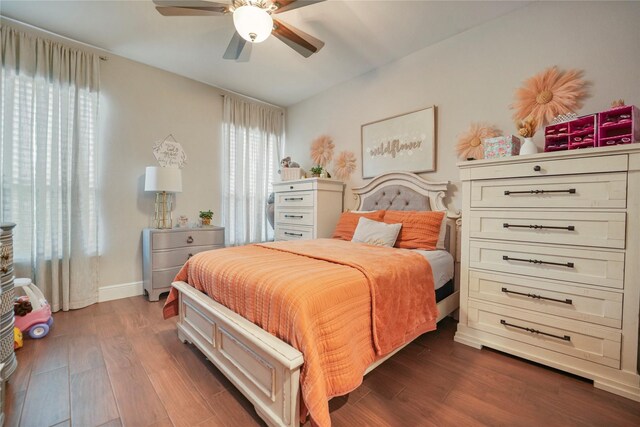 bedroom with dark wood-style floors, baseboards, and ceiling fan