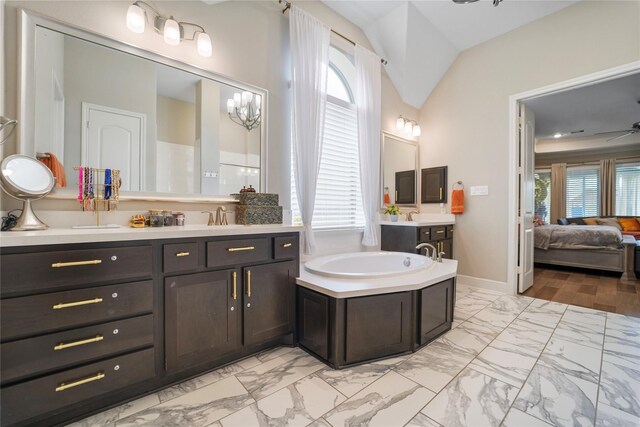 full bath featuring marble finish flooring, a bath, lofted ceiling, baseboards, and a ceiling fan