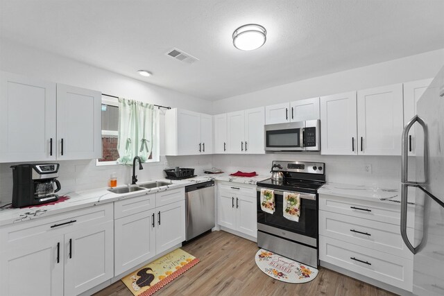 5927 Warm Springs Rd, Houston, TX 77035 - kitchen with stainless steel appliances, a sink, white cabinets, and decorative backsplash