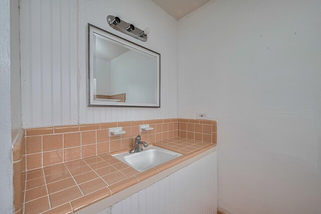 bathroom featuring a sink and decorative backsplash