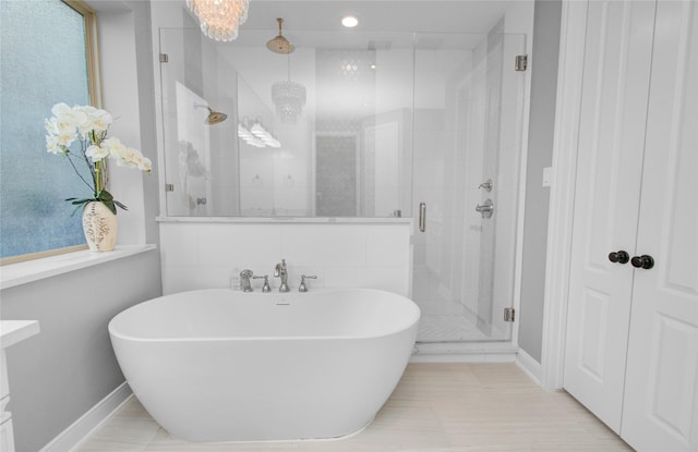 9803 White Rock Lake Trl, Cypress, TX 77433 - full bathroom featuring a shower stall, a soaking tub, baseboards, a chandelier, and recessed lighting
