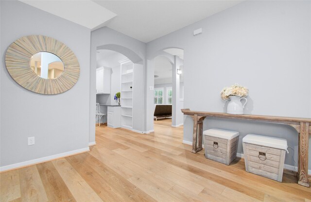9803 White Rock Lake Trl, Cypress, TX 77433 - hall featuring arched walkways, light wood-style floors, and baseboards