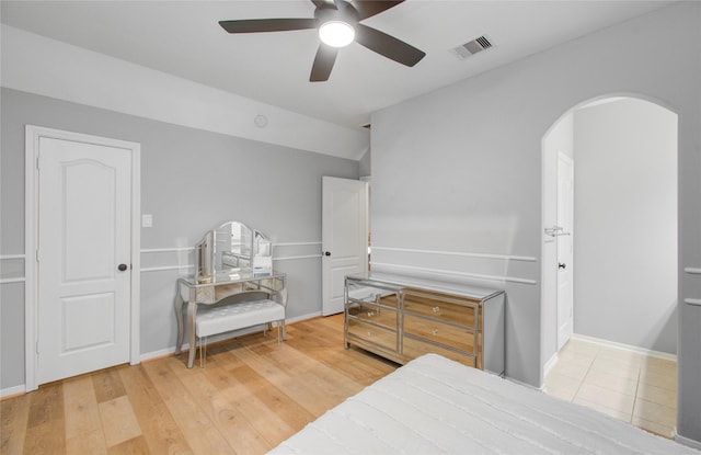 9803 White Rock Lake Trl, Cypress, TX 77433 - bedroom featuring arched walkways, ceiling fan, and wood finished floors