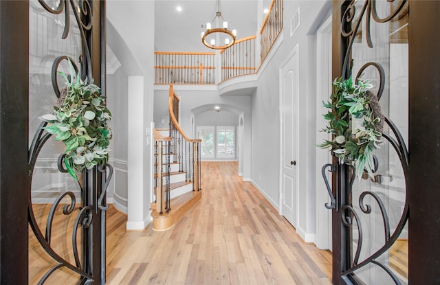 9803 White Rock Lake Trl, Cypress, TX 77433 - entrance foyer featuring arched walkways, stairs, light wood-style floors, a high ceiling, and a chandelier