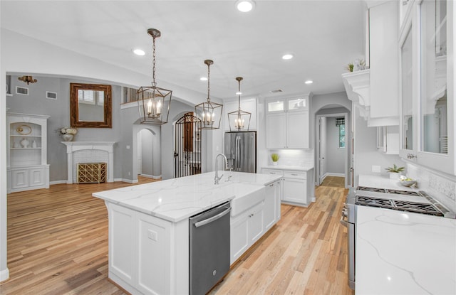9803 White Rock Lake Trl, Cypress, TX 77433 - kitchen with arched walkways, appliances with stainless steel finishes, a sink, white cabinets, and recessed lighting
