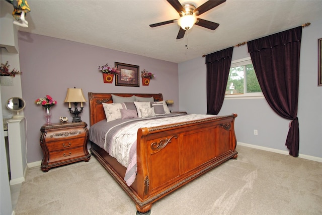 bedroom with light carpet, baseboards, and ceiling fan