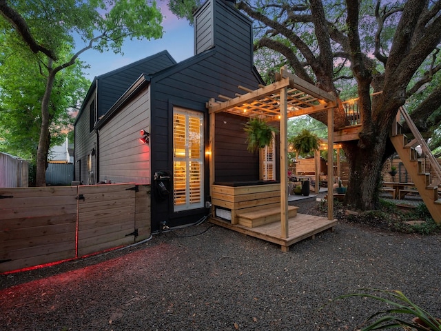 view of side of property with fence, a chimney, and a pergola